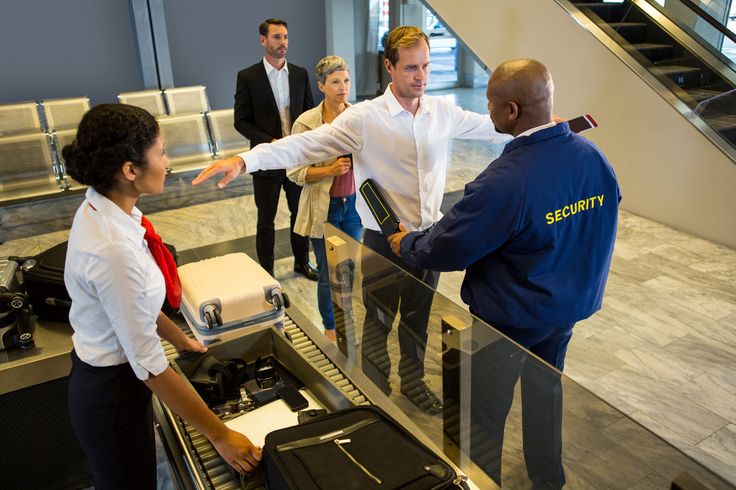 Security guard frisking passengers with metal…